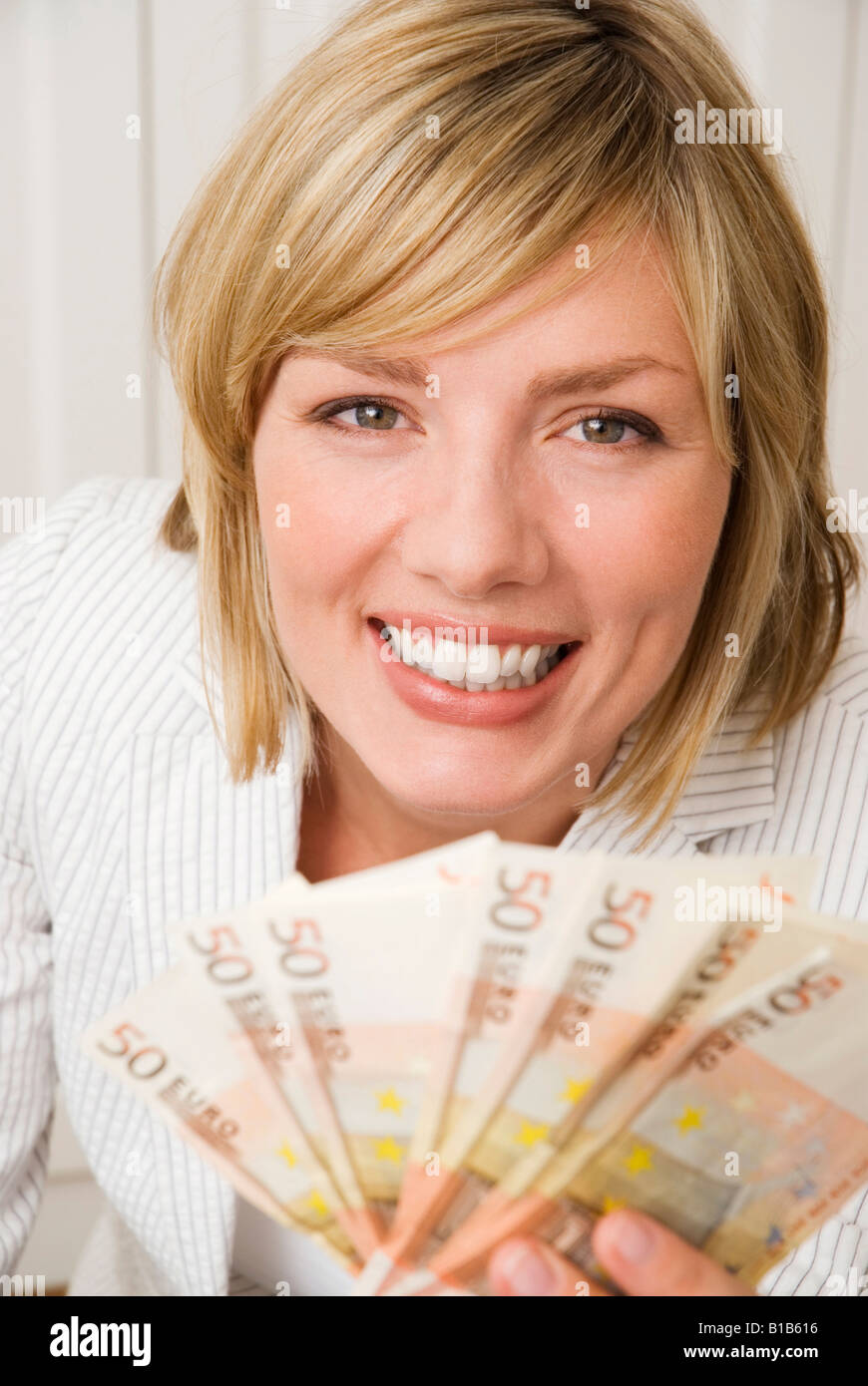 Woman holding 50 Euro, smiling, portrait Banque D'Images