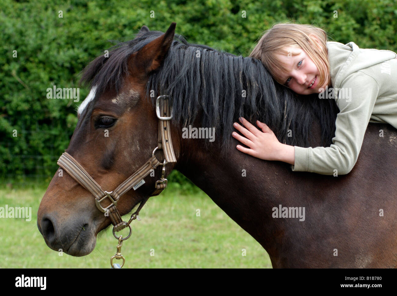 Petite fille appuyée sur son pony Banque D'Images