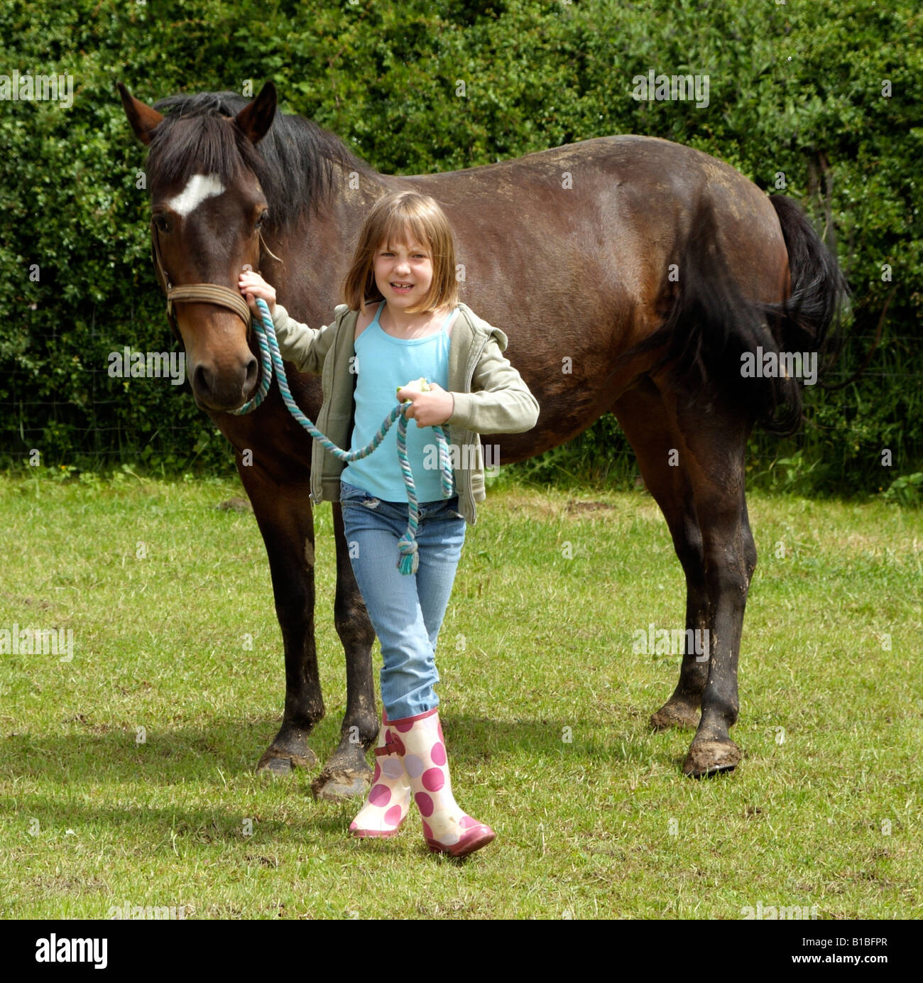 Little girl holding sa pony par le rein Banque D'Images