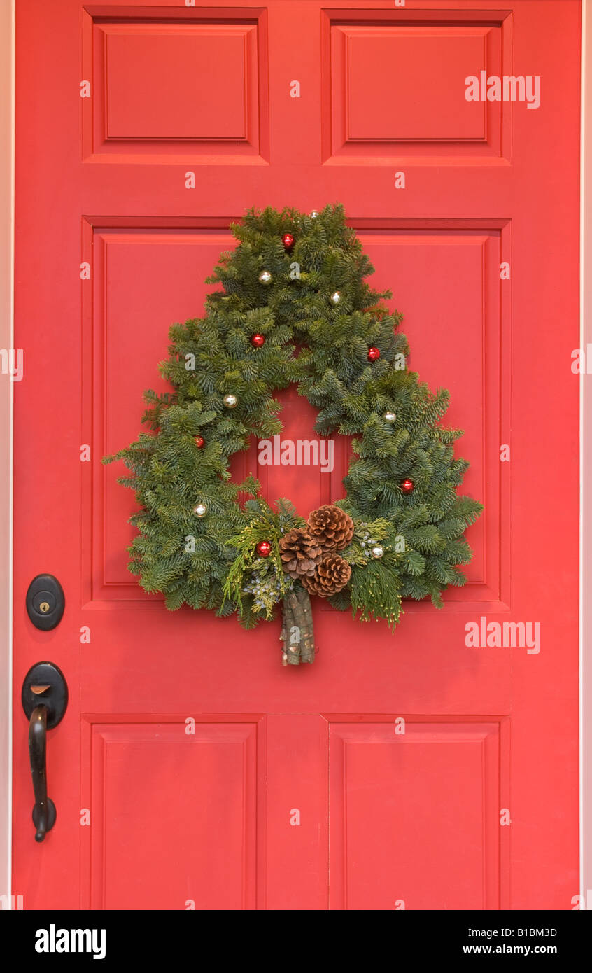 Avec une porte rouge couronne en forme d'arbre de Noël Banque D'Images