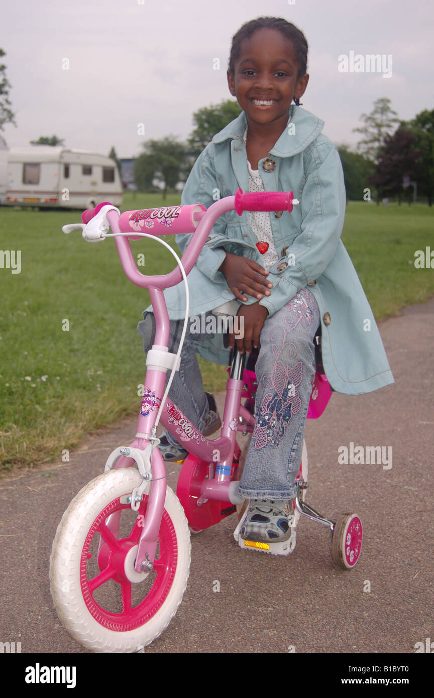 Beautiful smiling afro-caribéenne girl on bike Banque D'Images