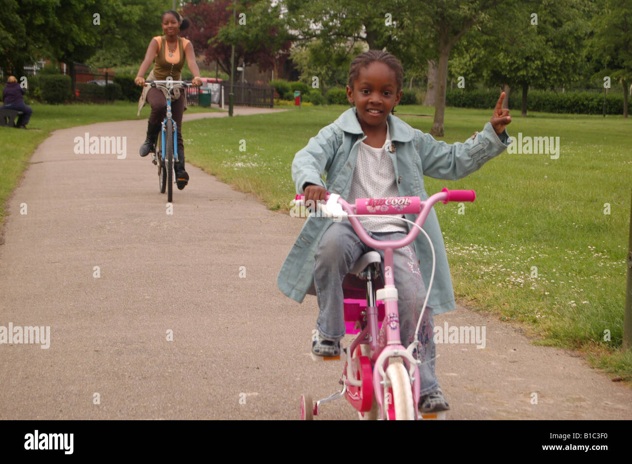 Les enfants afro-caraïbes riding bikes in park Banque D'Images