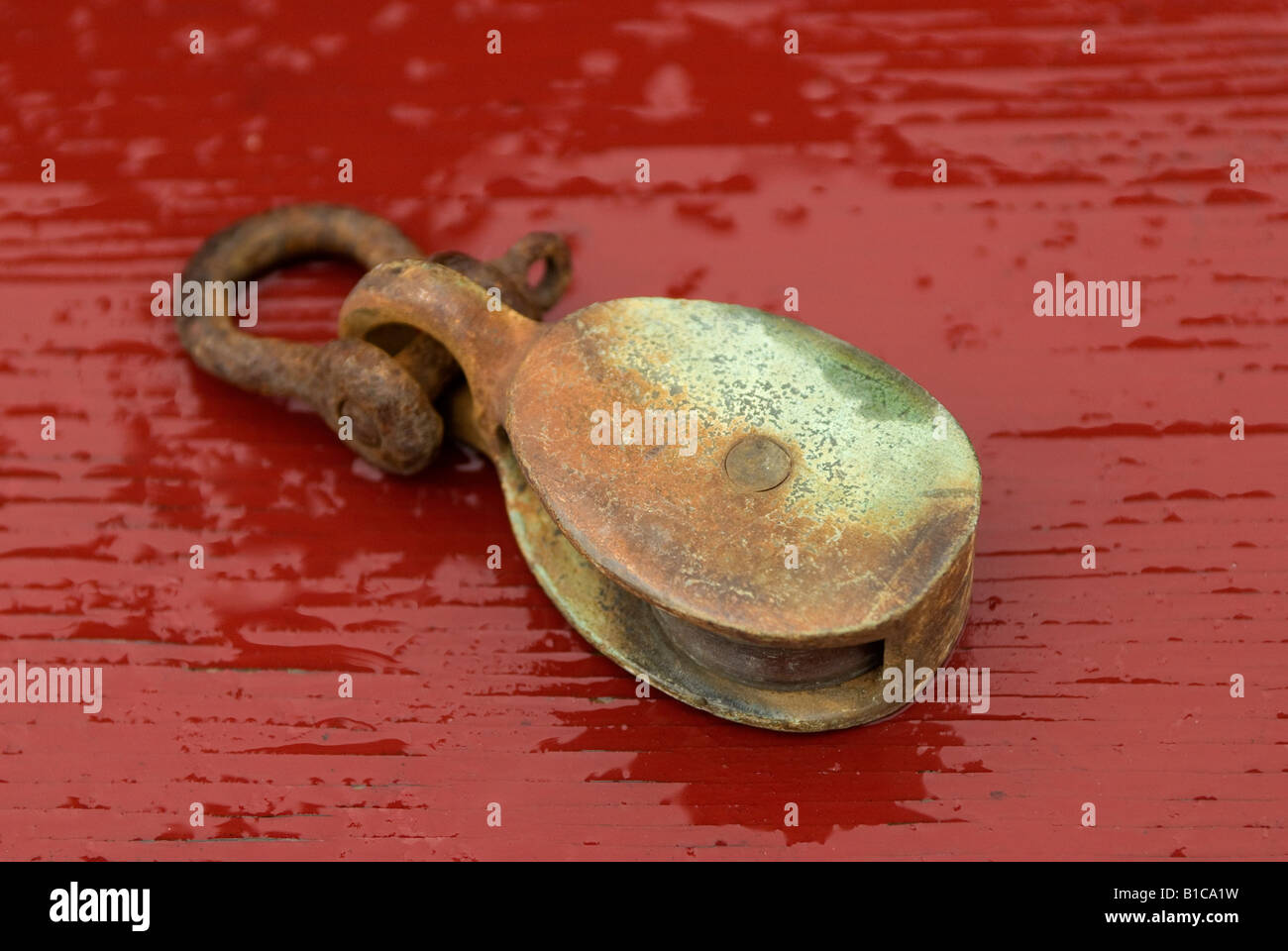 Manille rouillée sur une surface rouge. Banque D'Images