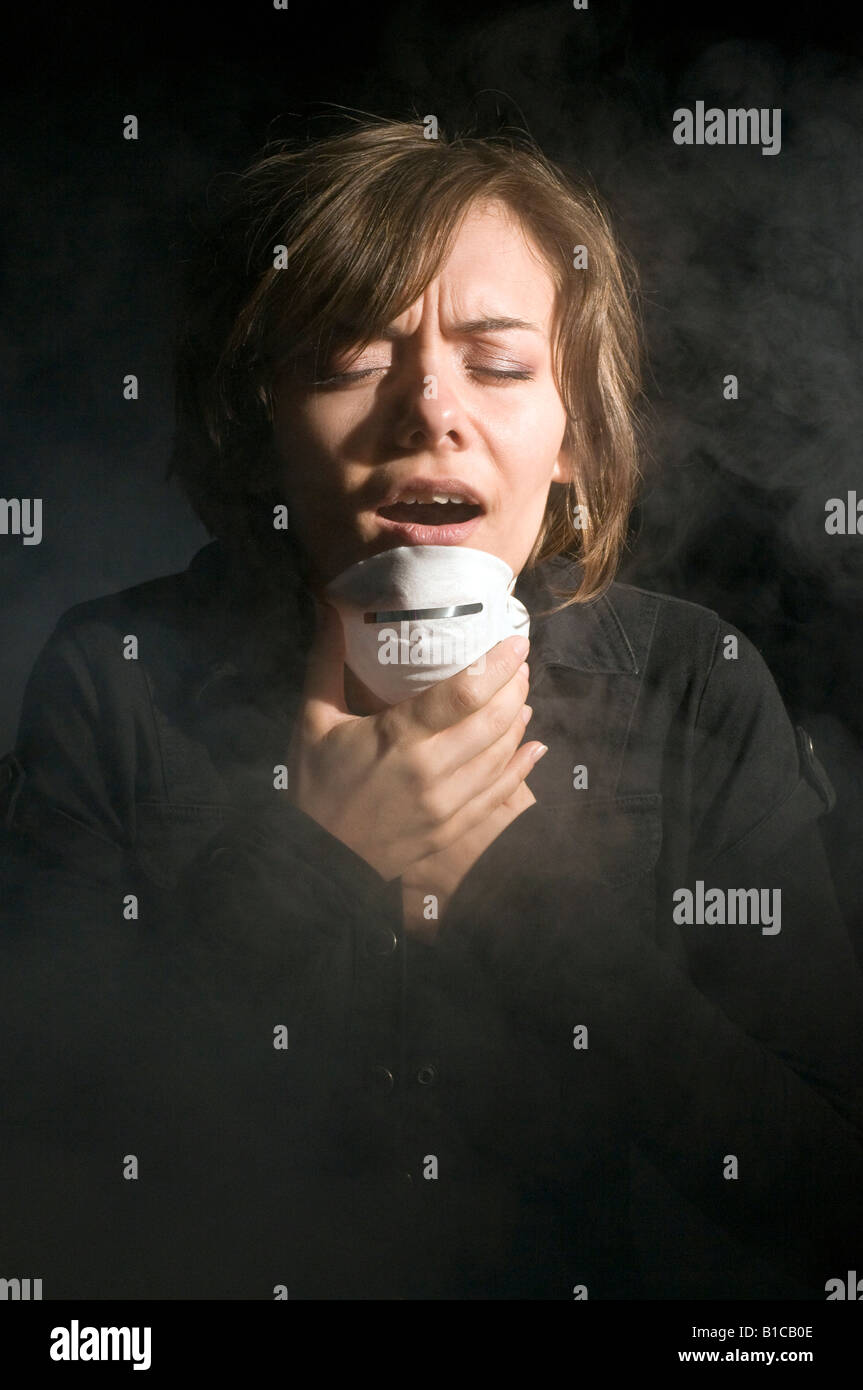 Femme en masque médical à l'intérieur de nuages de fumée Banque D'Images