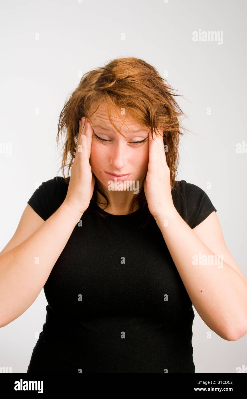 Jeune femme Rousse aux cheveux rouges avec maux de gueule de mauvais malades dans la douleur en frottant son front Banque D'Images