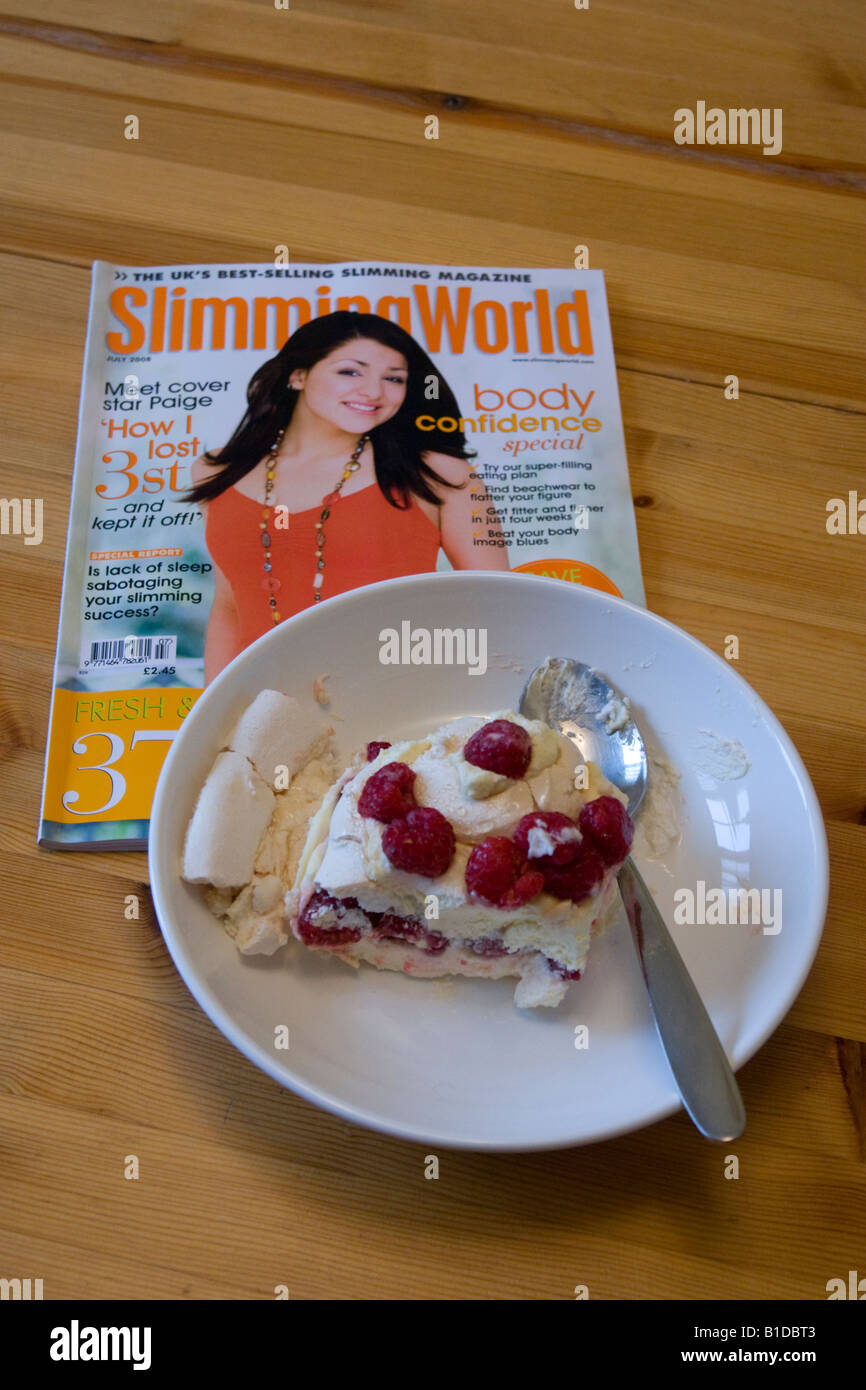 Slimming World Magazine et grand morceau de gâteau Banque D'Images