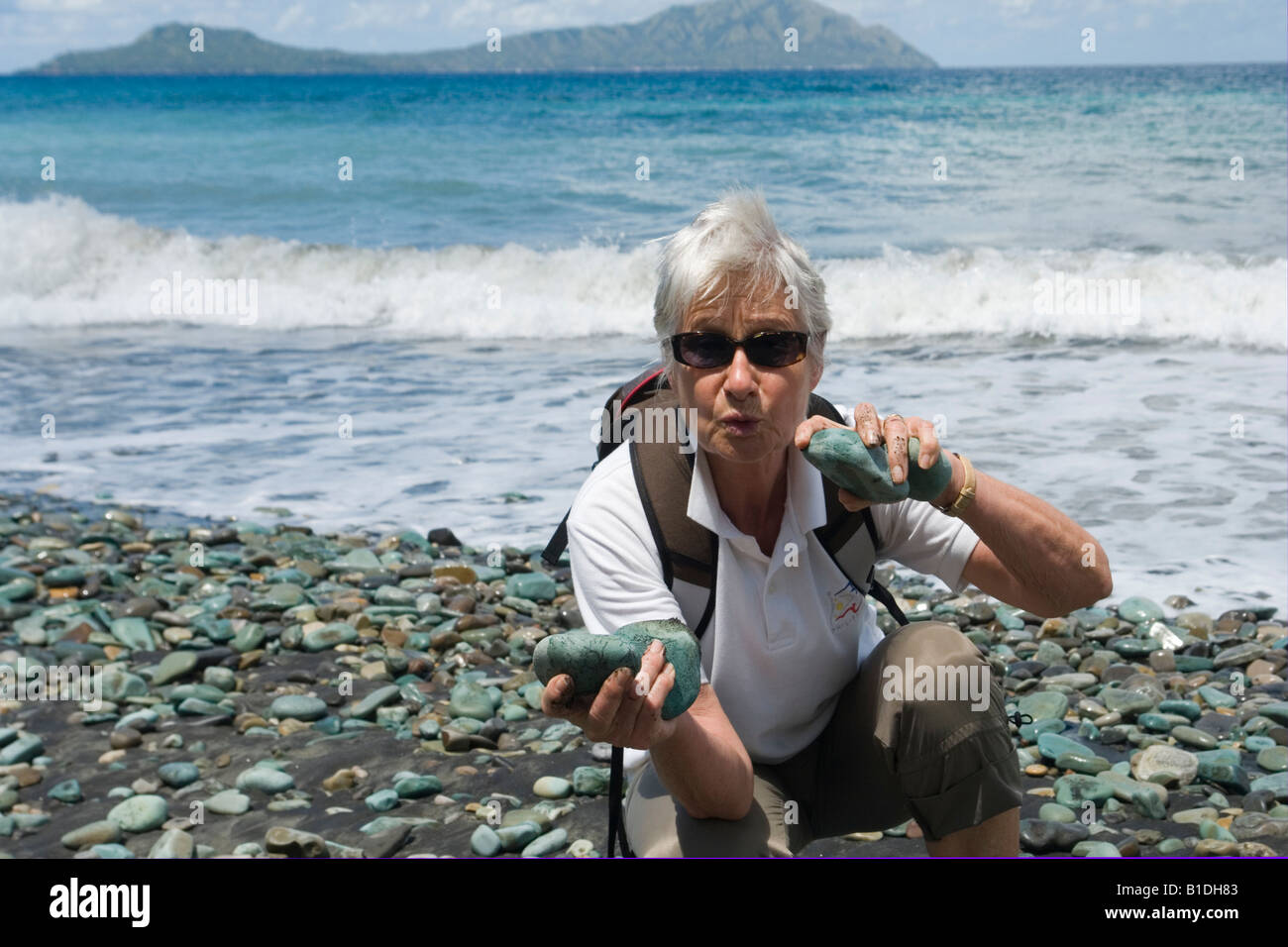 Une dame la collecte de cailloux bleus touristiques souvenirs (Flores - Indonésie). Une touriste collectant des galets bleus (Florès). Banque D'Images