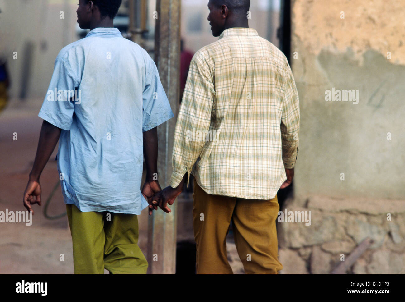 Deux hommes se tenir la main dans l'amitié en vous promenant dans un  village, la Côte d'Ivoire Photo Stock - Alamy