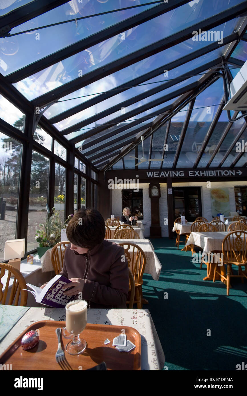 Un touriste est l'étude d'un guide de l'Ecosse dans le restaurant d'un whisky visitors center. Banque D'Images