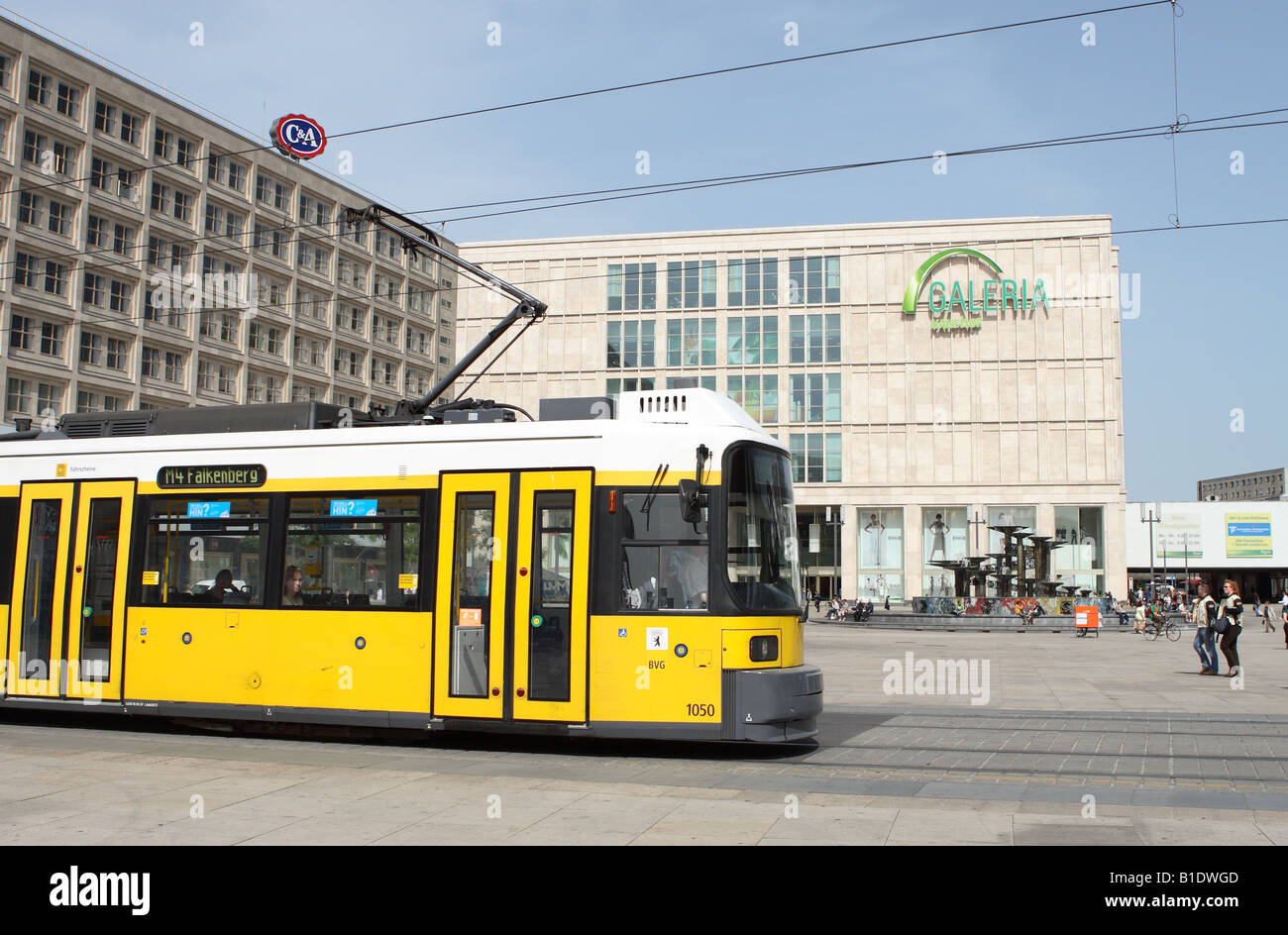 Allemagne Berlin Alexanderplatz BVG jaune passe à travers le réseau de tramway de la place Alexanderplatz en face du centre commercial Galleria Mall Banque D'Images