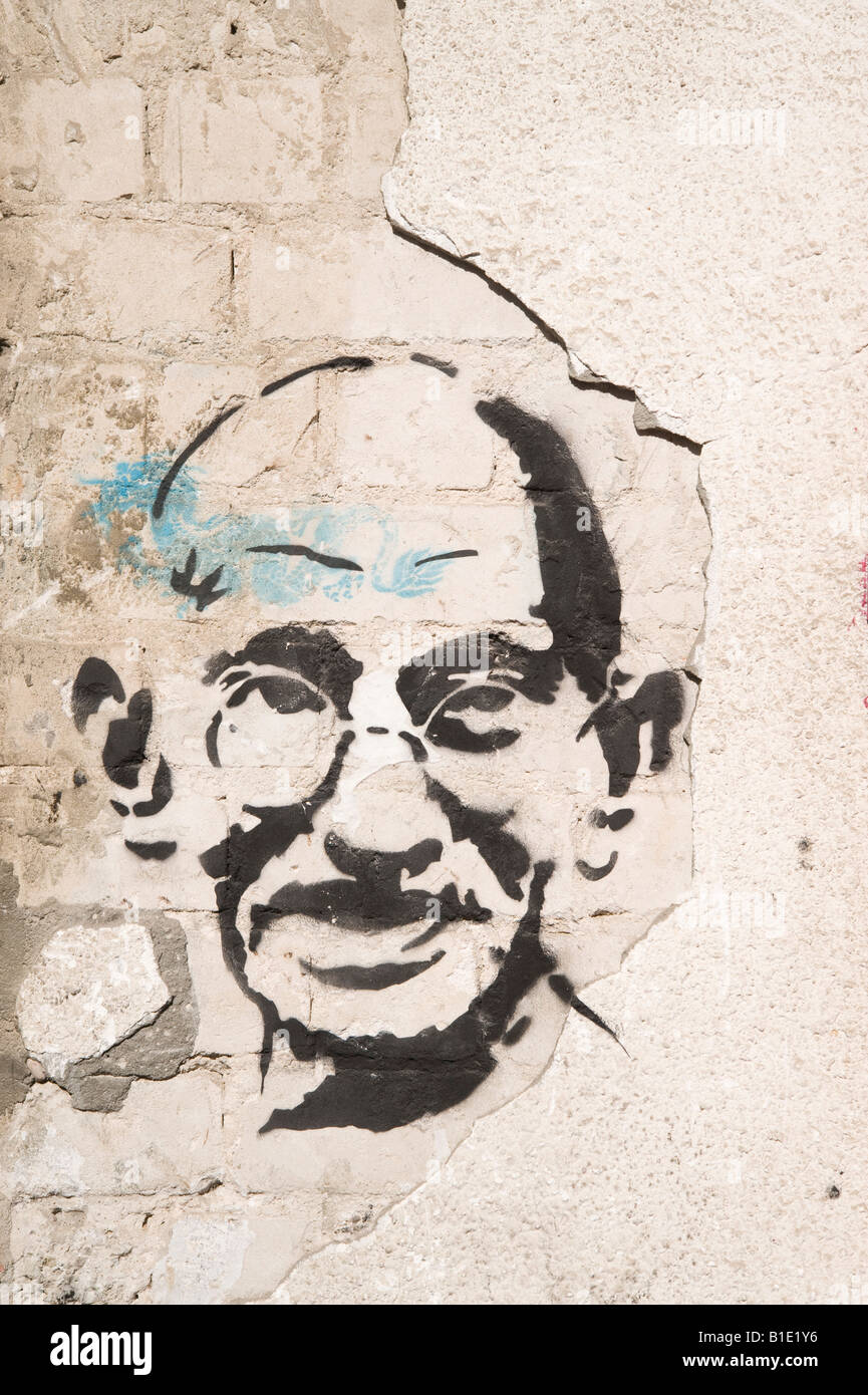 Israël Tel Aviv Graffiti de Mahatma Gandhi sur un vieux mur fissuré délabré Banque D'Images