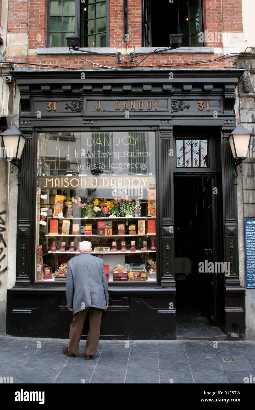 Un vieil homme contemple le chocolats et friandises disponibles dans un vieux sweet-shop window Banque D'Images