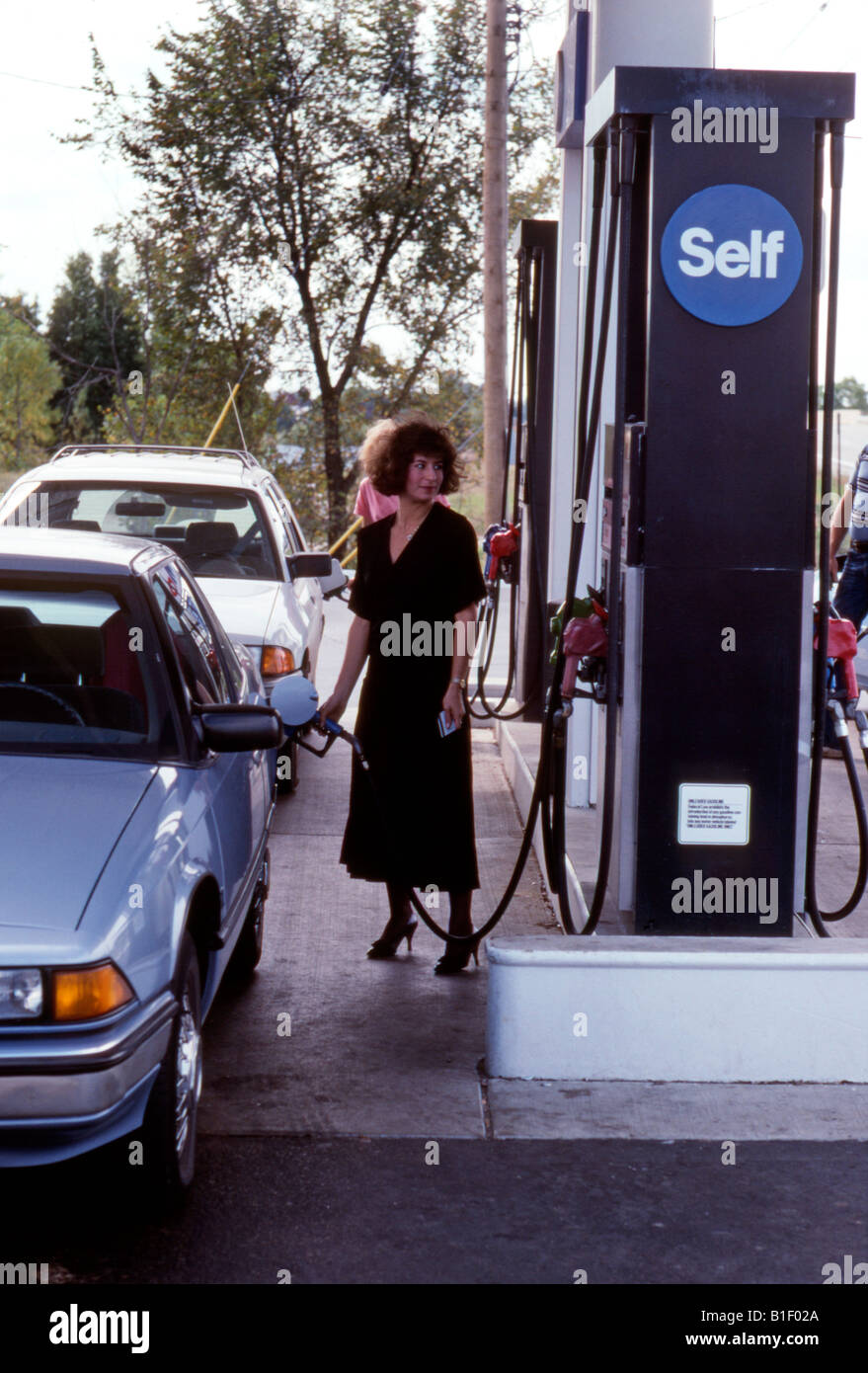 Pompes à essence femme dans sa voiture à la station-service Banque D'Images