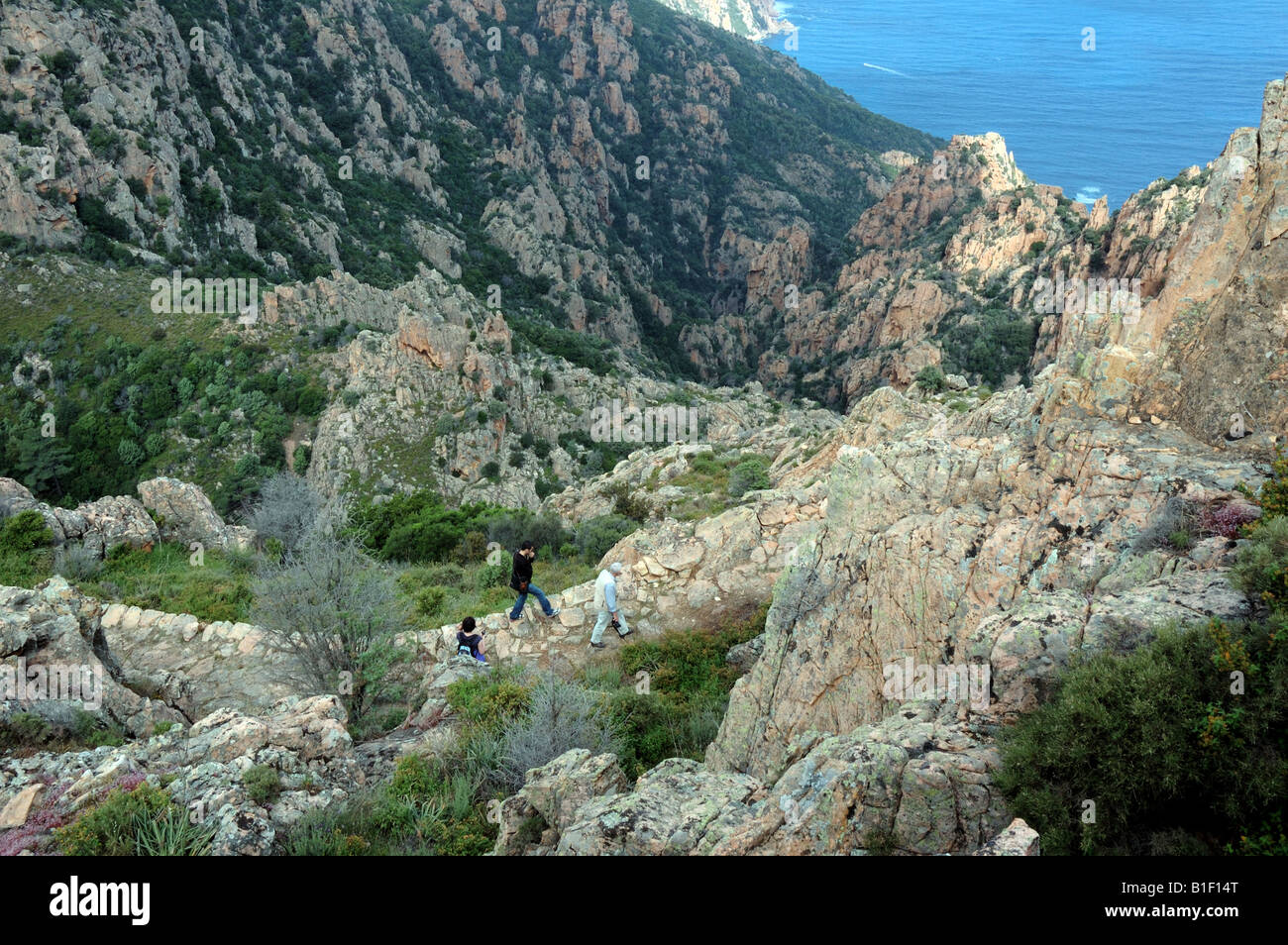 Randonneurs sur un sentier pédestre dans les Calanques de Piana, Corse, France. Banque D'Images