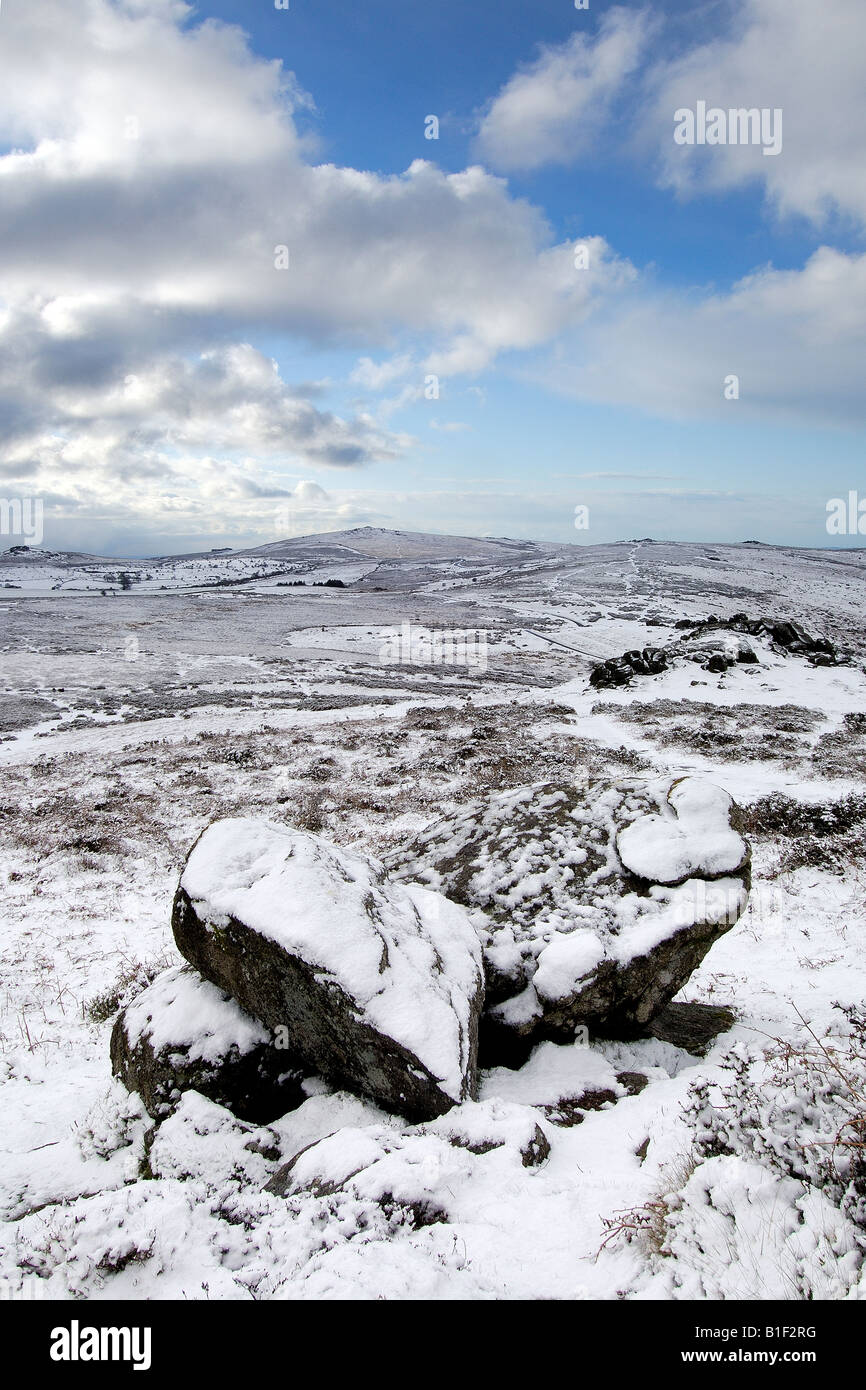 Le poids de la neige près de Chinkwell Tor sur le parc national du Dartmoor avec deux rochers de granit à l'avant-plan et un ciel nuageux Banque D'Images