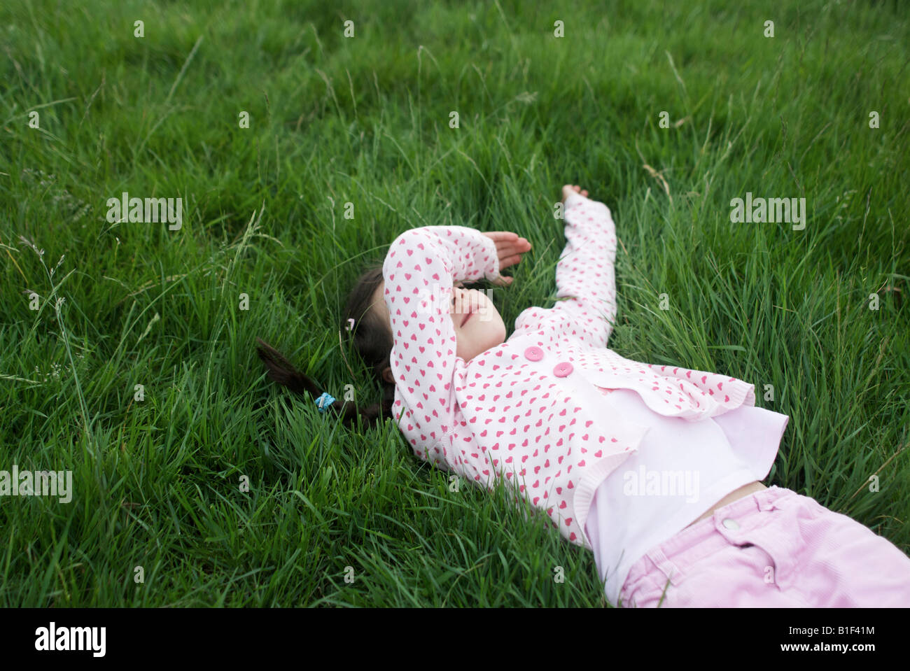 Fille pose dans l'herbe 6 ans Banque D'Images