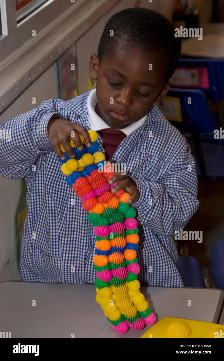Jeune écolier jouant avec un jouet de construction Banque D'Images