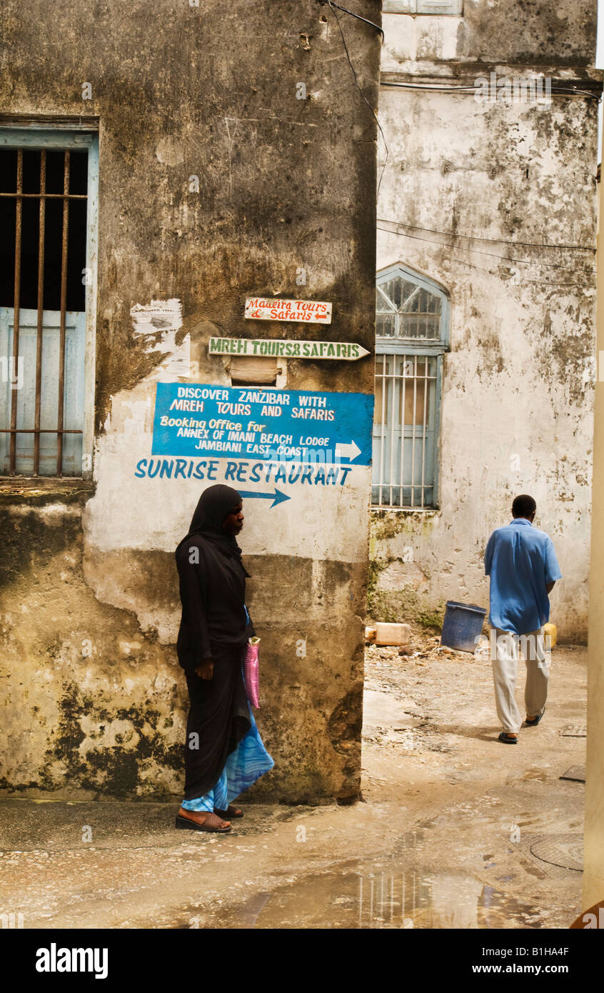Femme et homme marchant dans la ruelle de Stonetown, Zanzibar est de la Tanzanie. Banque D'Images