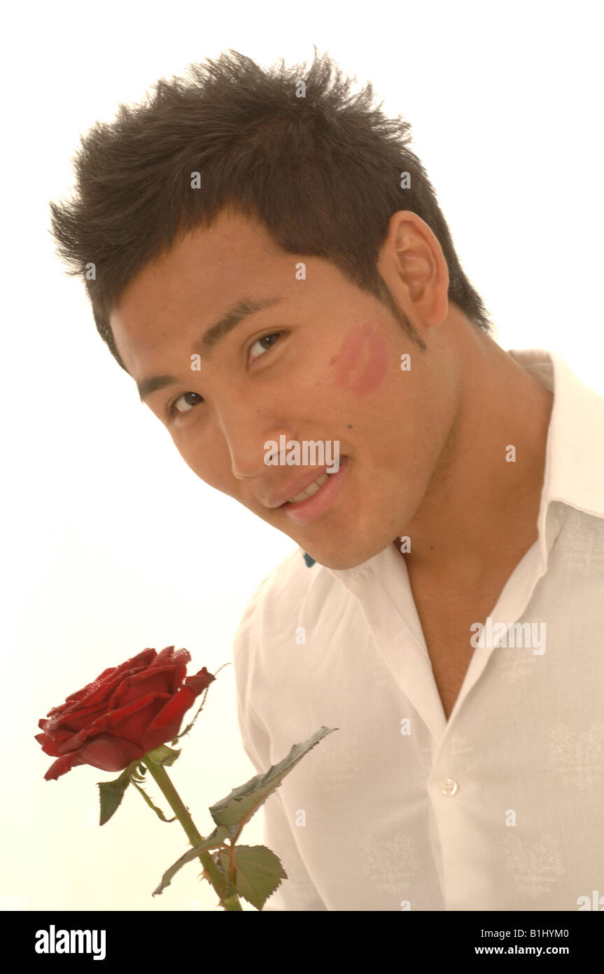 L'homme asiatique avec une rose rouge et kissmouth sur son chèque Banque D'Images