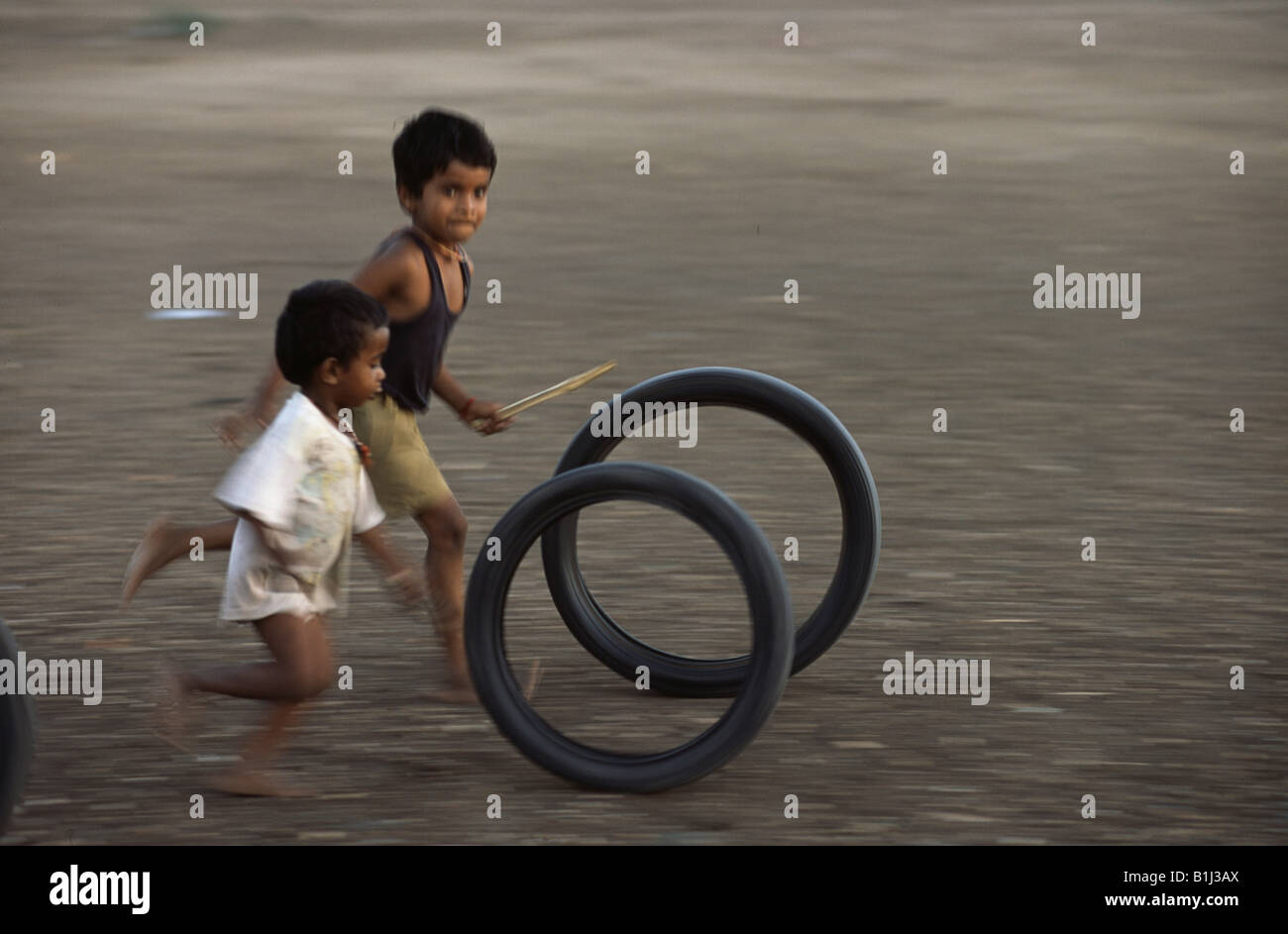 Deux garçons jouant avec des pneus, Tamil Nadu, Inde Banque D'Images