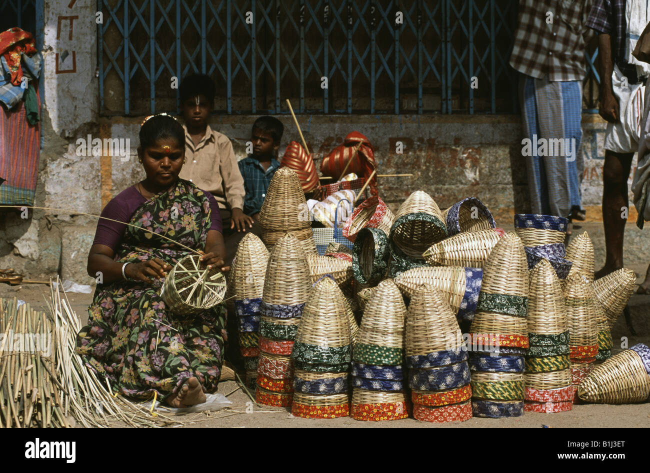 Mid adult woman weaving un panier de bandes du bambou, Tamil Nadu, Inde Banque D'Images