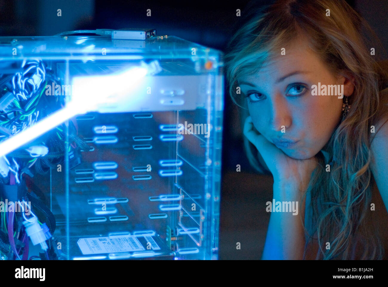 Jeune femme à la recherche d'un côté, impuissants, boîtier de l'ordinateur transparent Banque D'Images