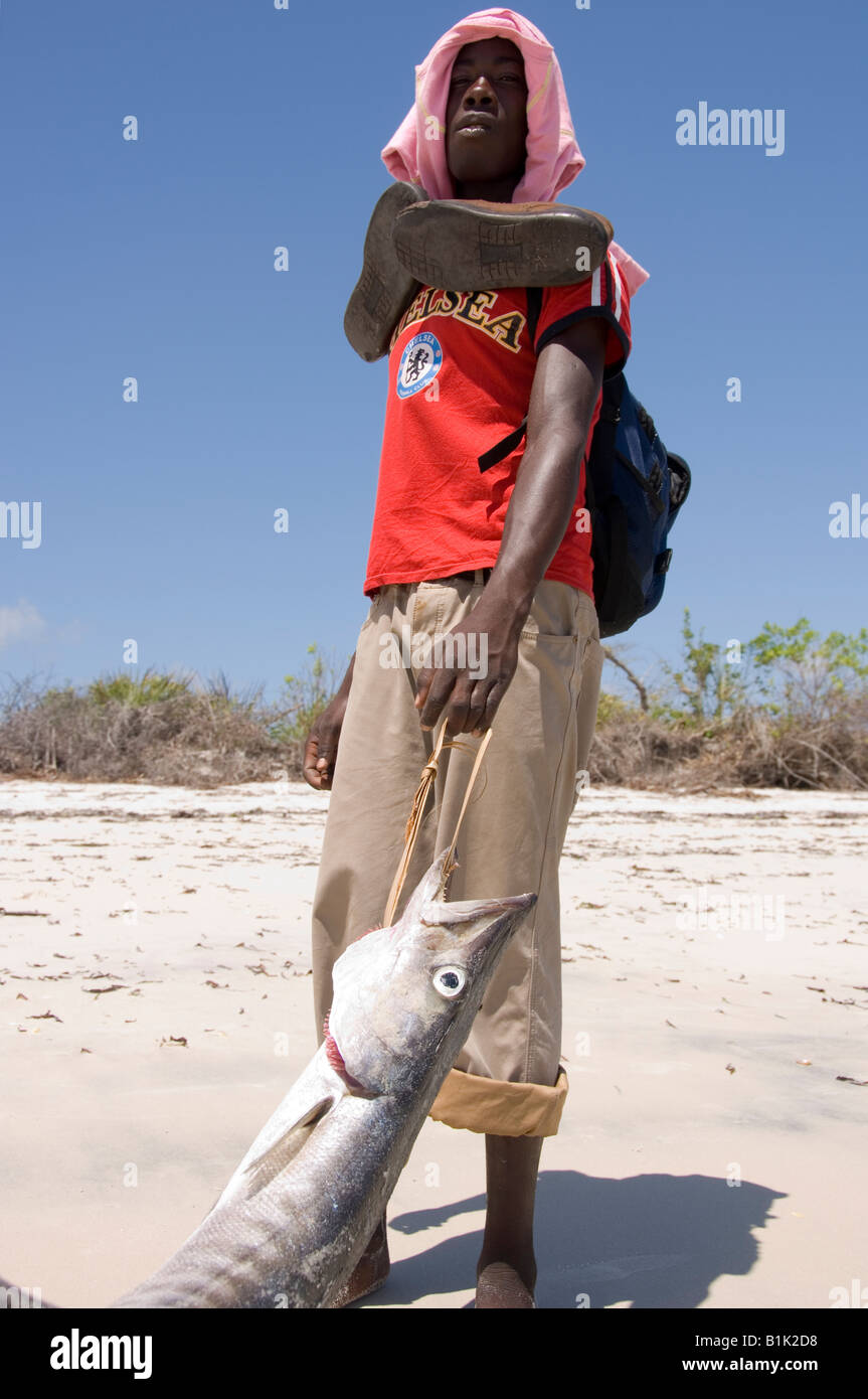 Homme portant un grand barracuda fraîchement pêchés le long de la plage de  Pangane. Mozambique Photo Stock - Alamy