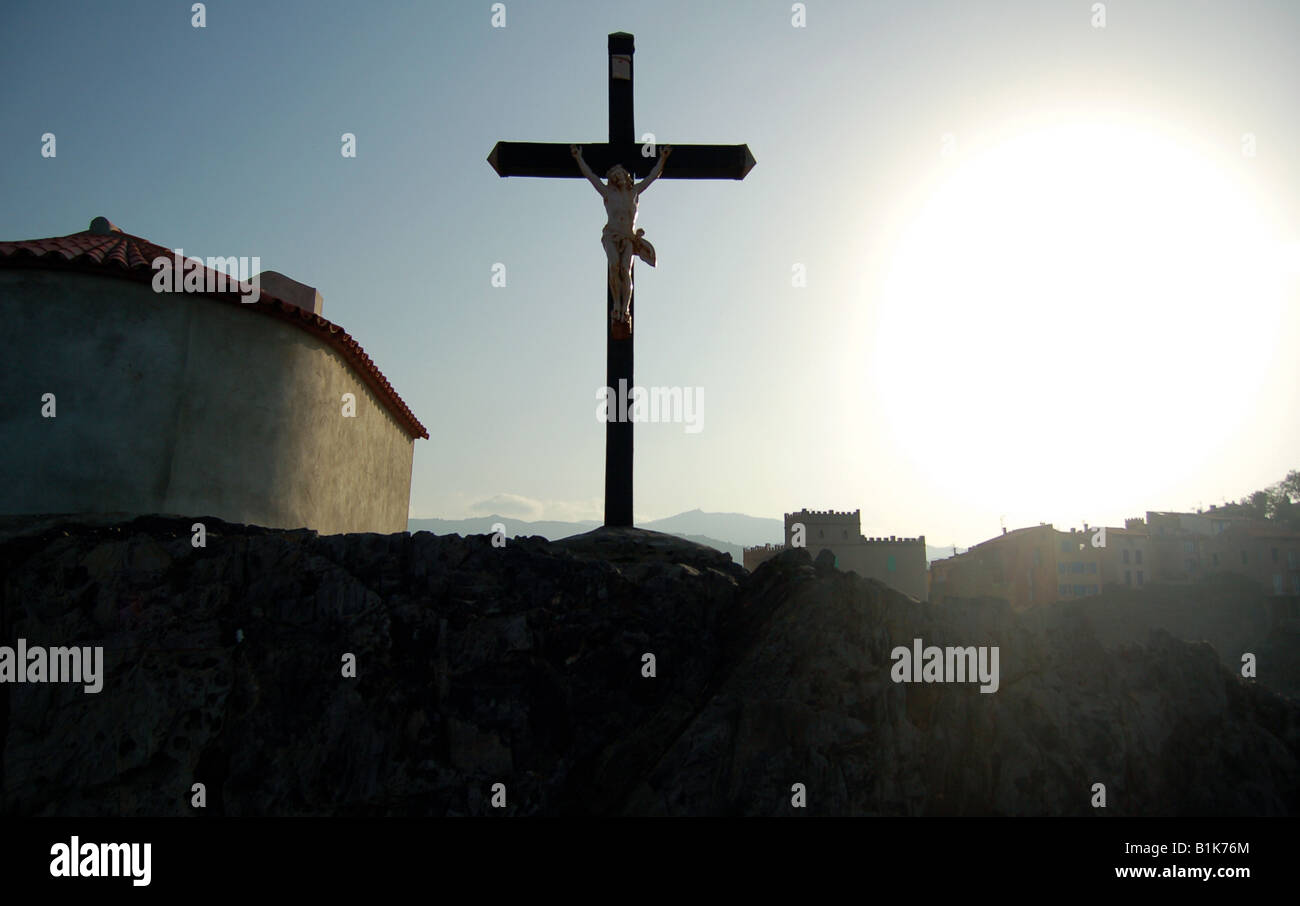 Silhouette crucifix dramatique sur les rochers de la magnifique village de Collioure, dans le sud de la France. Banque D'Images