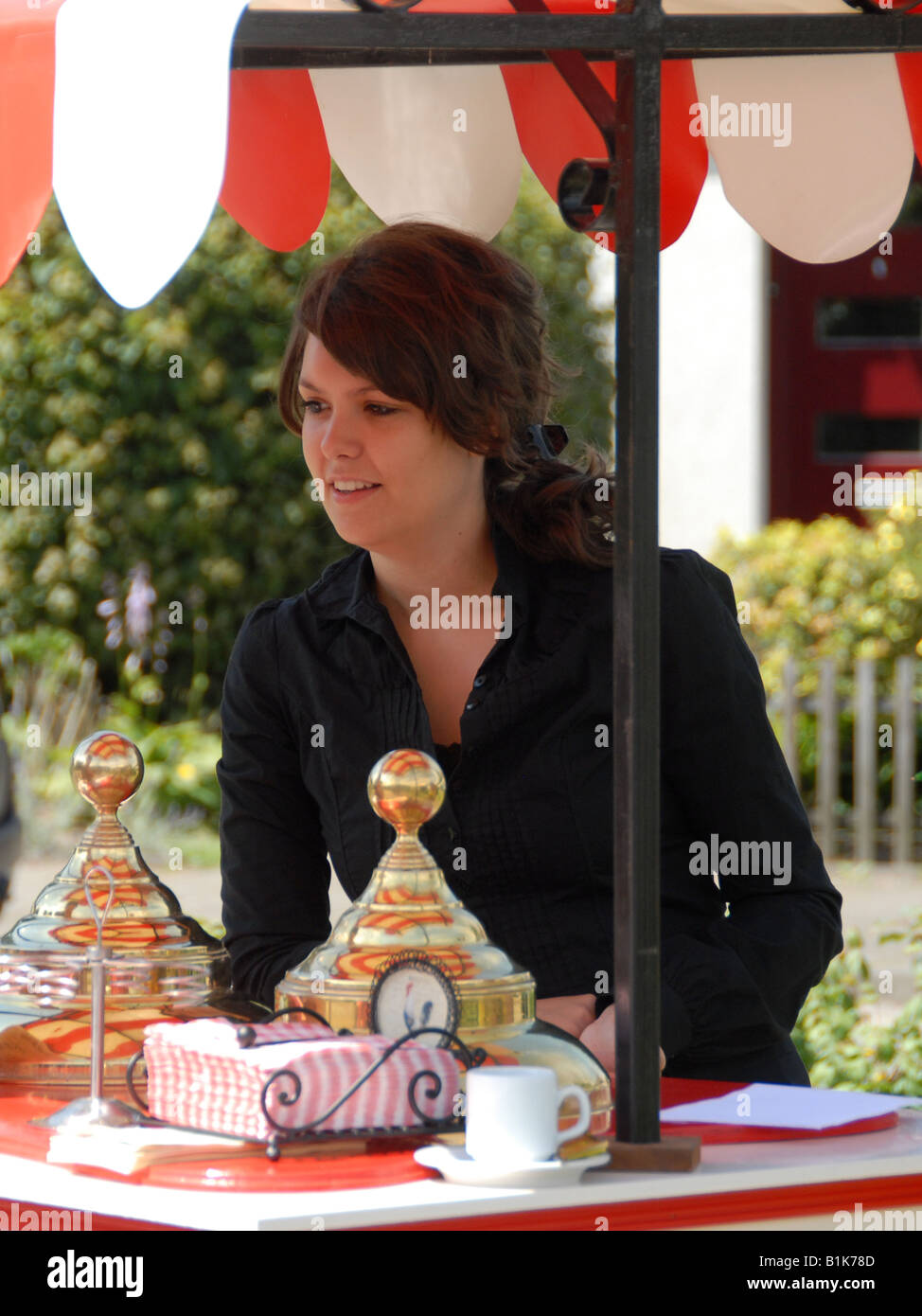 Une belle fille est la vente de la crème glacée dans un stand. Banque D'Images