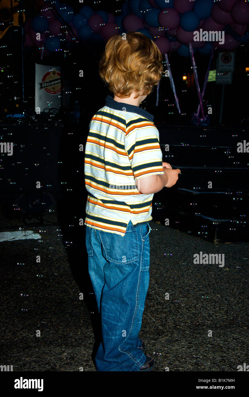 Jeune garçon jouer en face d'une machine à bulle de savon lors d'un concert à la mort Pas encore d'événements de bienfaisance Banque D'Images