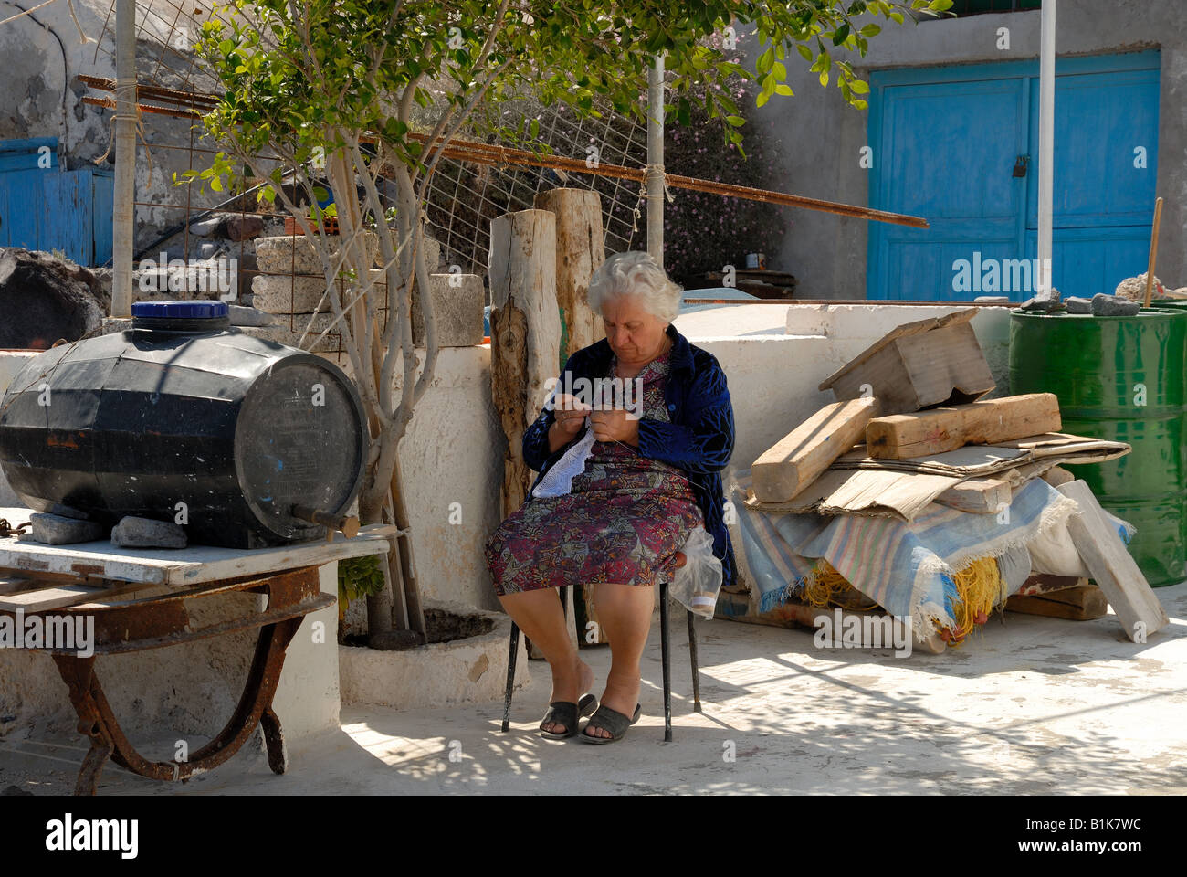 Une vieille dame le tricot devant sa maison, Grèce Banque D'Images