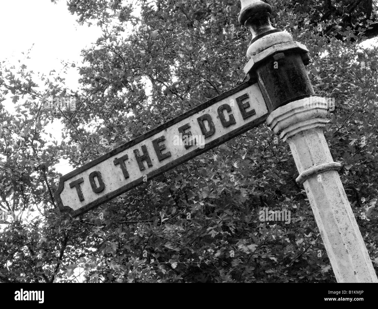 Ancien fer à repasser sign post disant À LA PÉRIPHÉRIE. À Wilmslow, Cheshire, près de Manchester. Photographie en noir et blanc. Monochrome. Banque D'Images