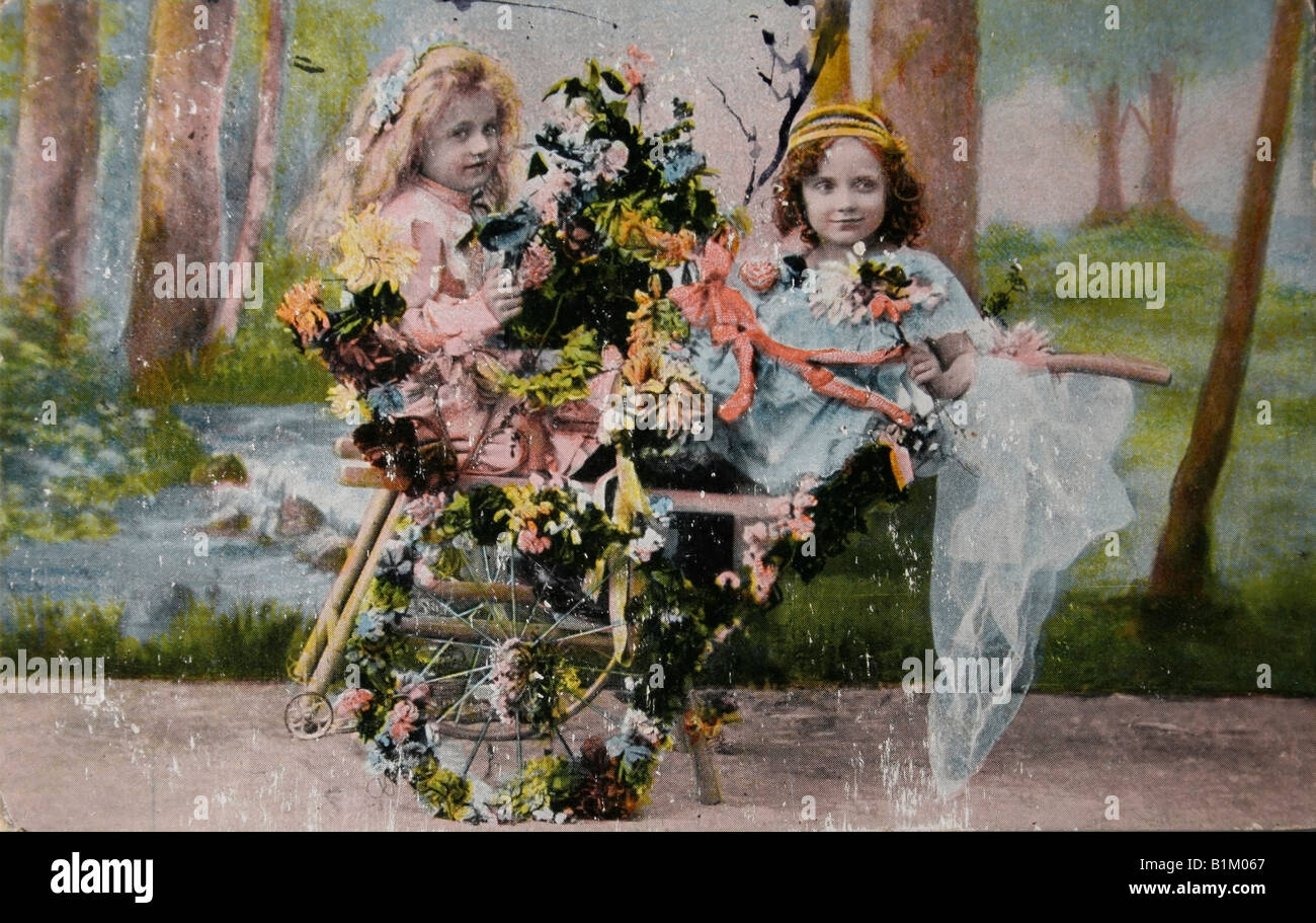 Vintage postcard (1909) de deux petites filles un panier et de fleurs Banque D'Images