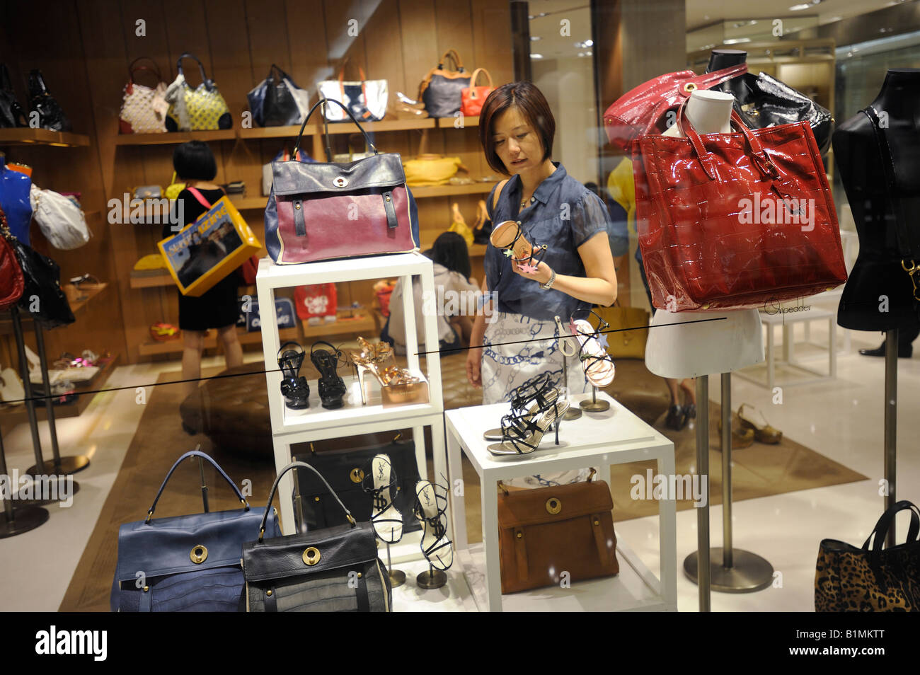 Une femme chinoise shopping dans un magasin de chaussures et sacs luxious dans Shin Kong Place à Pékin, en Chine. 13-juin-2008 Banque D'Images