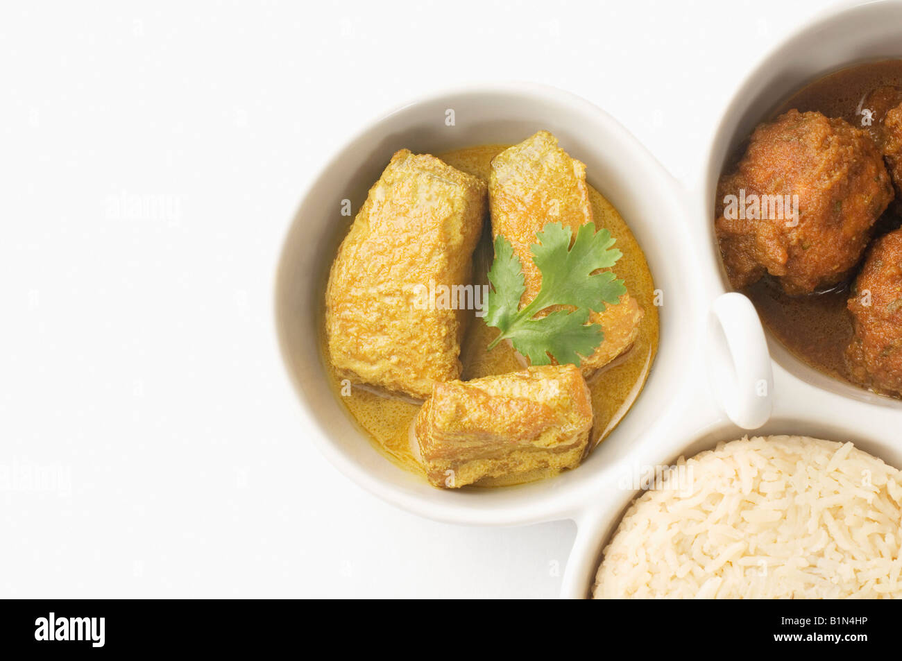 Close-up du riz bouilli et les boulettes avec curry de poisson servi dans des bols Banque D'Images