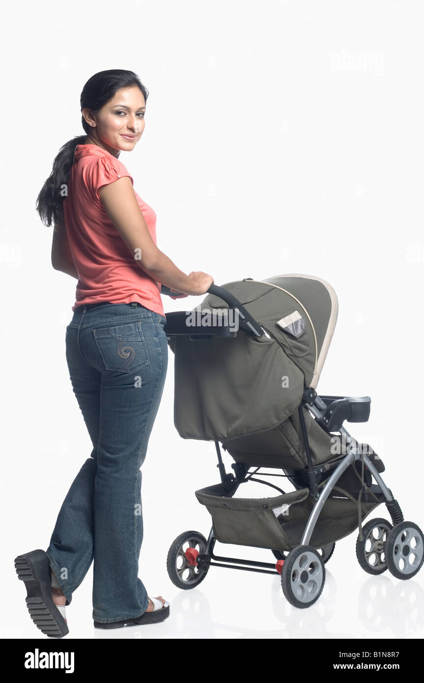 Mid adult woman holding a baby stroller Banque D'Images