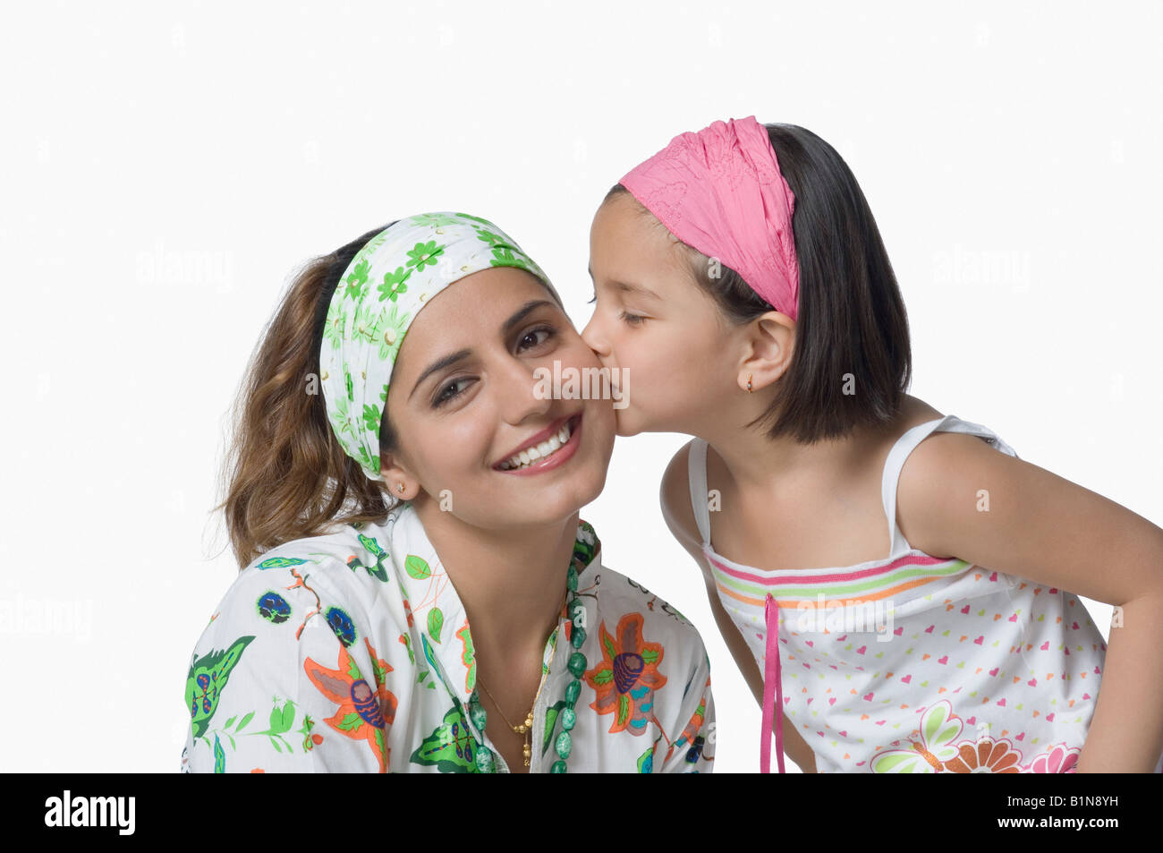 Close-up of a Girl kissing her mother and smiling Banque D'Images