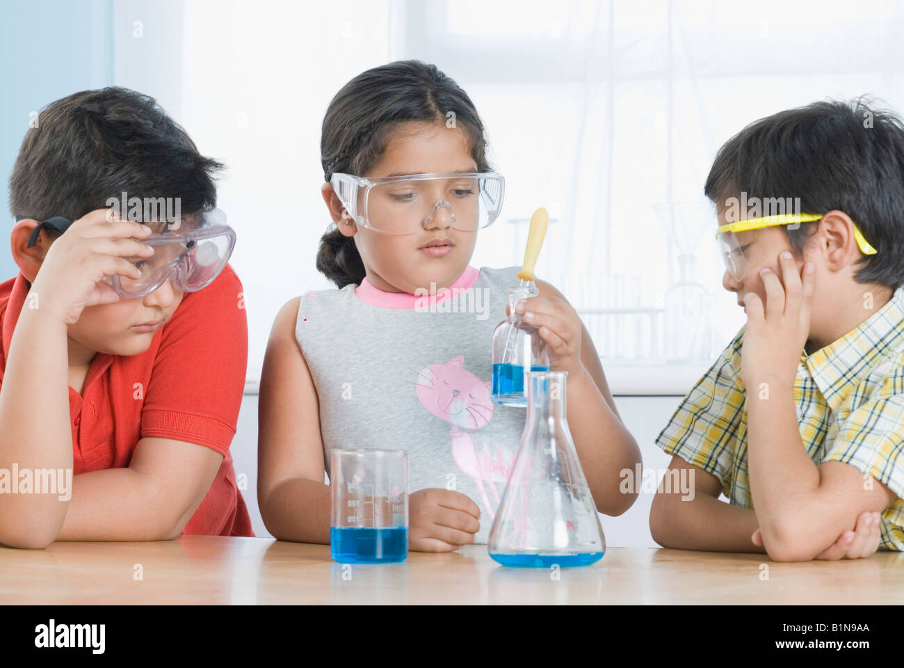 Fille avec d'autres étudiants dans un laboratoire d'expérience scientifique Banque D'Images