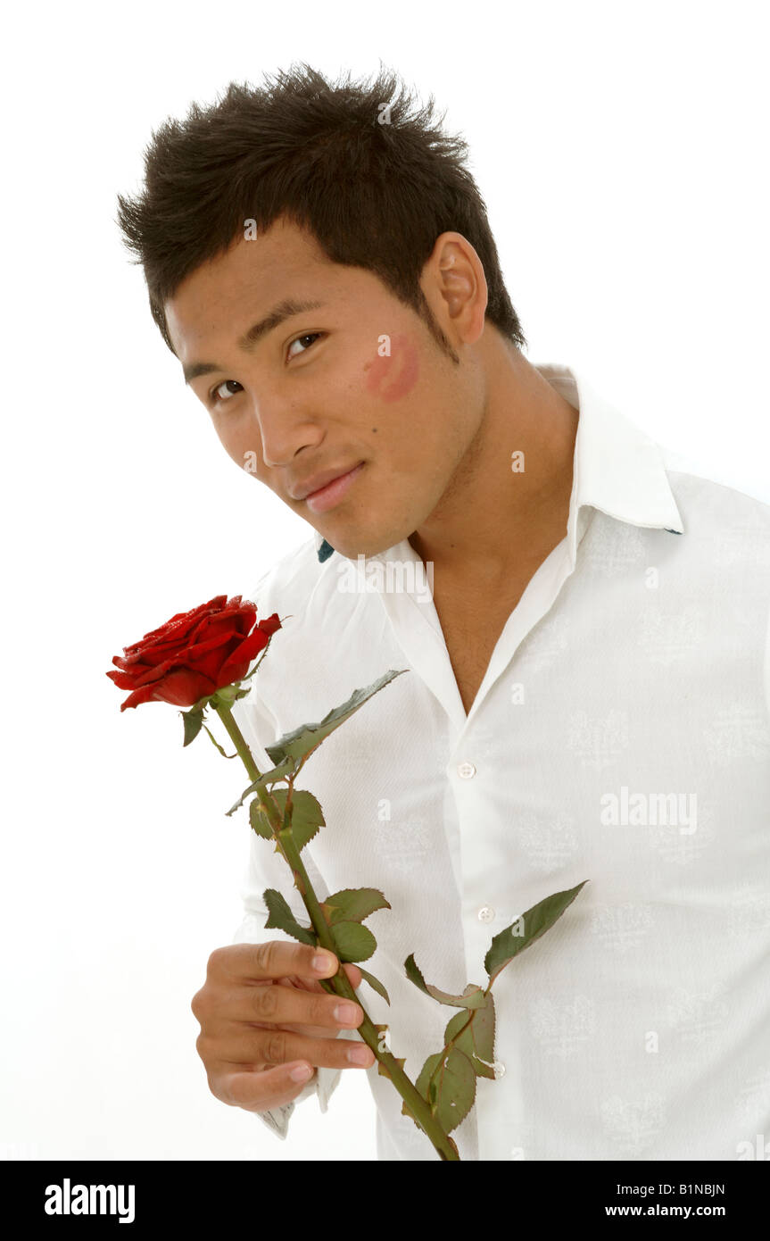 L'homme asiatique avec une rose rouge et kissmouth sur son chèque Banque D'Images