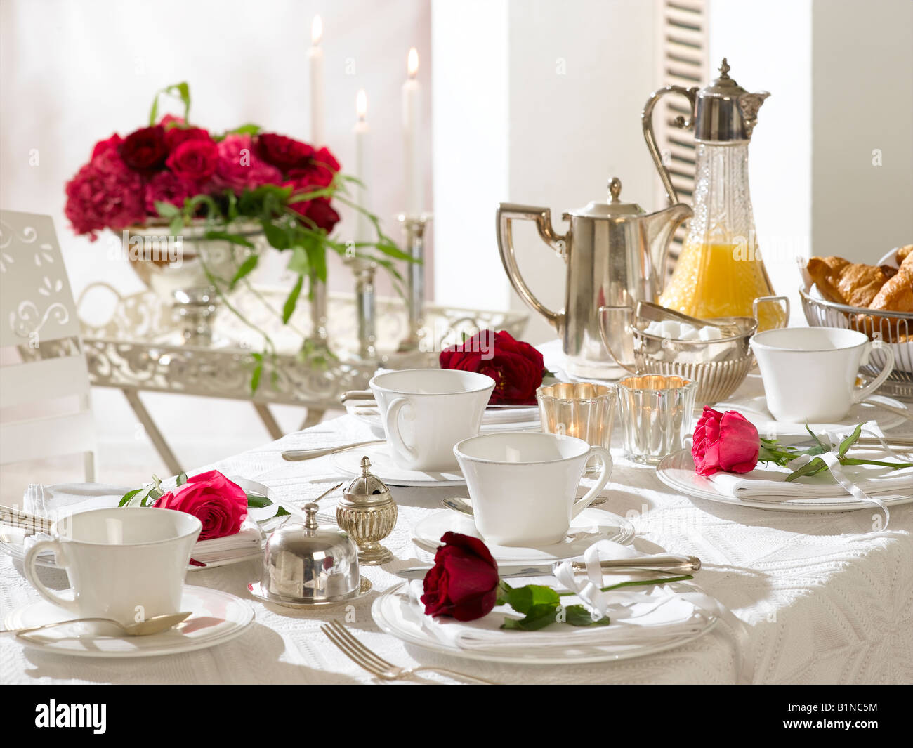 Table de petit-déjeuner décorée de roses rouges Banque D'Images