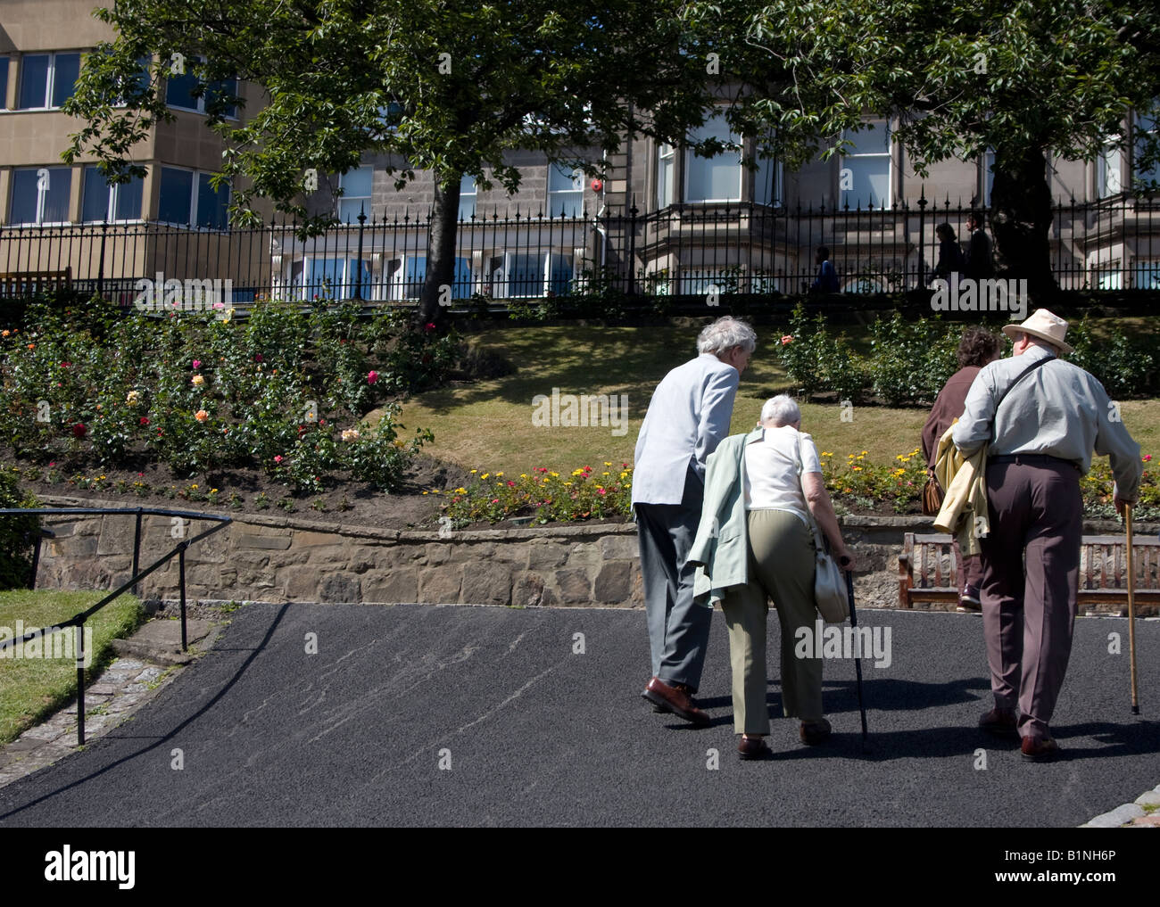 Deux couples de personnes âgées à monter une pente dans les jardins de Princes Street, Edinburgh UK - bénéficiant d'un jour d'été ensoleillé Banque D'Images