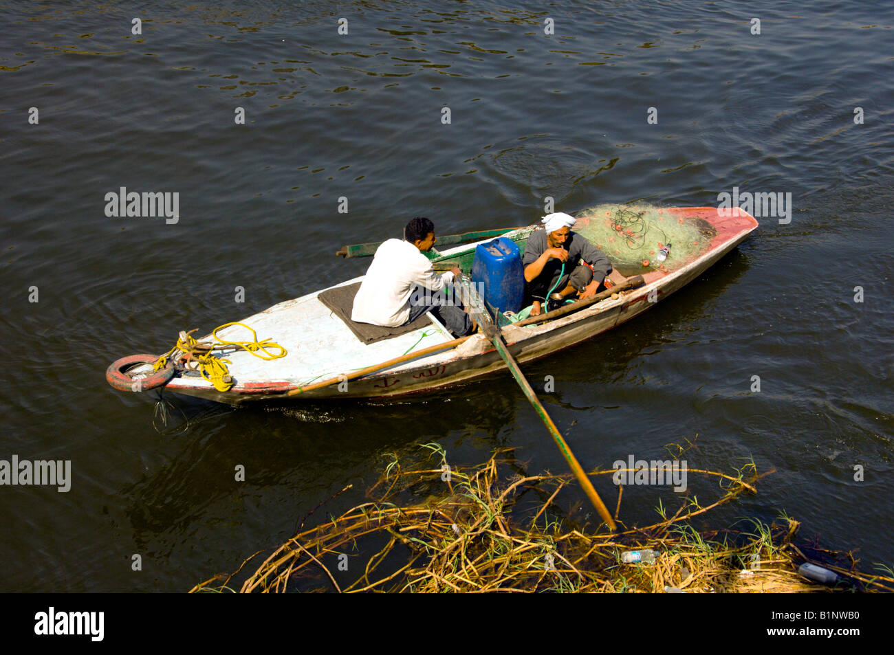 Un homme qui fume la chicha sur une petite barque dans le Nil au Caire, Egypte Banque D'Images