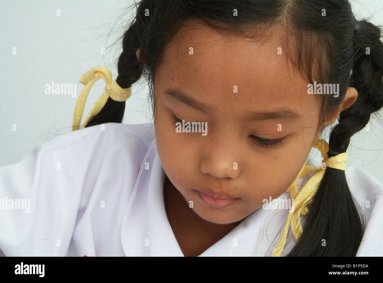 Portrait de Thai girl 8 ans dans l'uniforme scolaire Banque D'Images