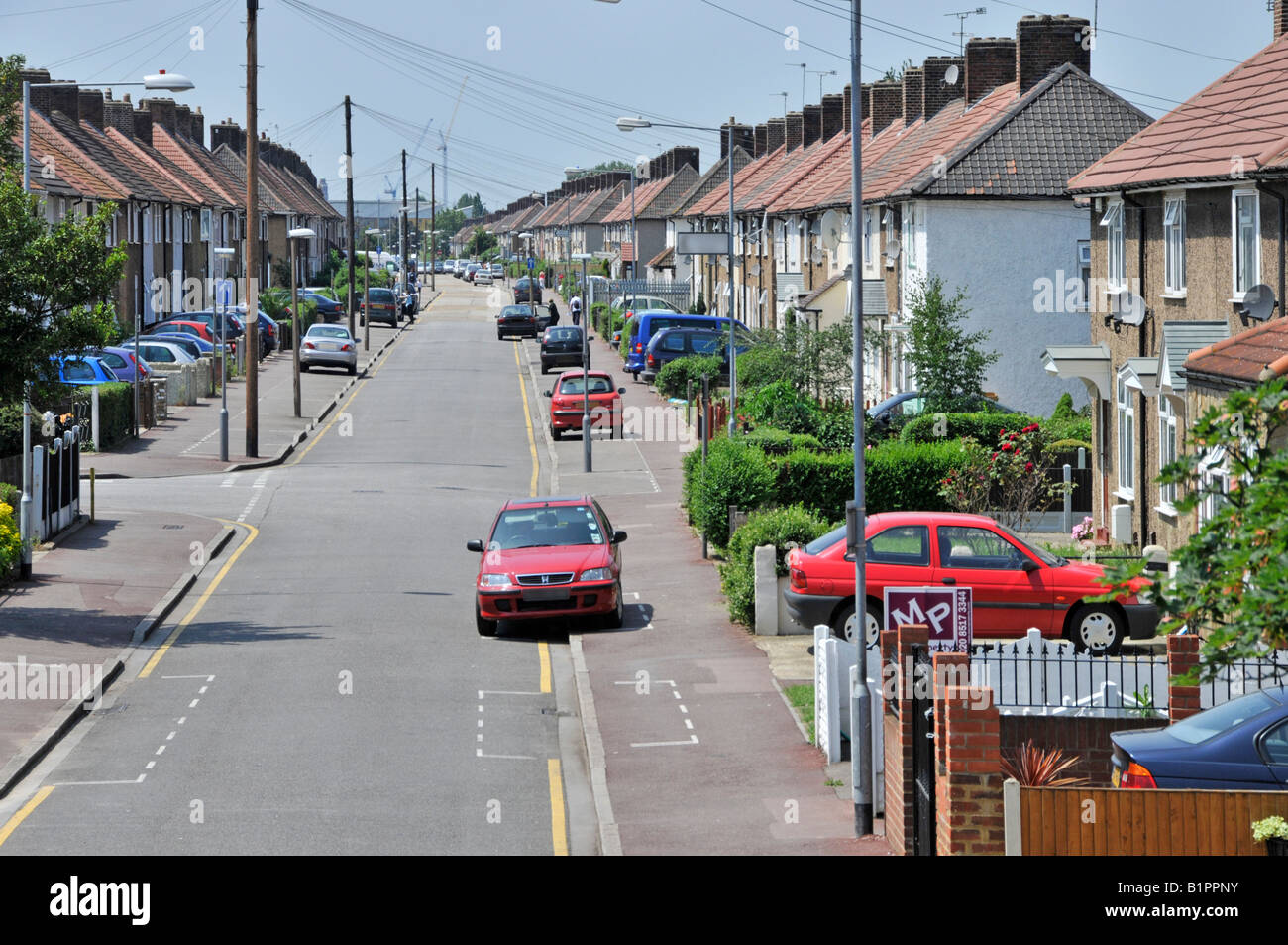 Vue sur la rue des voitures et des maisons de Becontree immobilier construit entre les guerres comme logement de conseil social Maisons Barking et Dagenham Royaume-Uni Banque D'Images