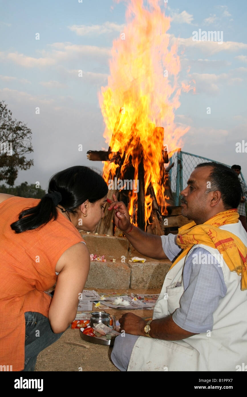 Prêtre hindou marque un adorateur avec une tikka au cours de la cérémonie du feu d'Holi Holika , fêtes , Inde Banque D'Images