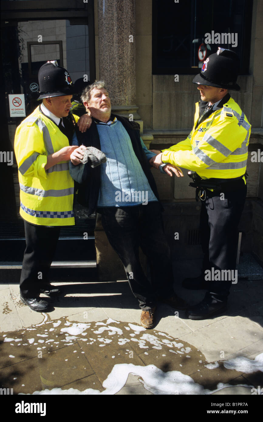 Homme ivre étant détenu par des agents de police à Manchester Banque D'Images