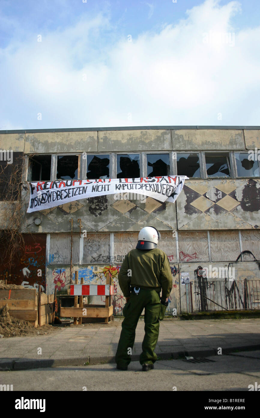 Agent de police surveillance d'une maison occupée par des squatters, Berlin, Germany, Europe Banque D'Images