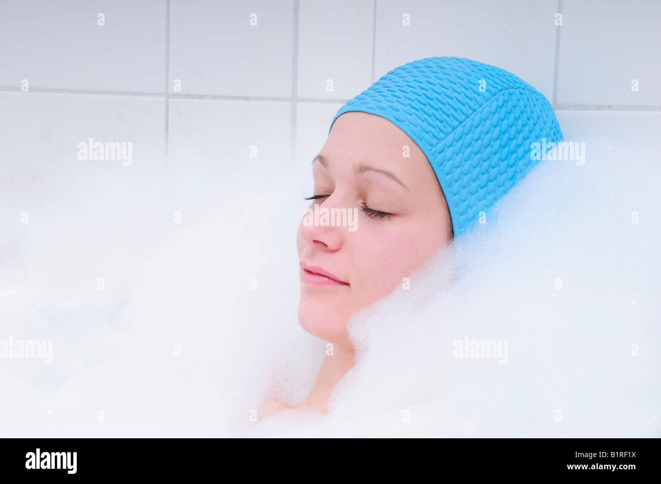Pretty young woman taking bath dans le bain et la détente, Bonnet bleu Banque D'Images