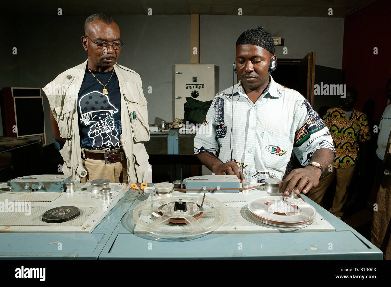 Les hommes debout devant des cassettes audio à une station de radio, Garoua, Cameroun, Afrique Banque D'Images
