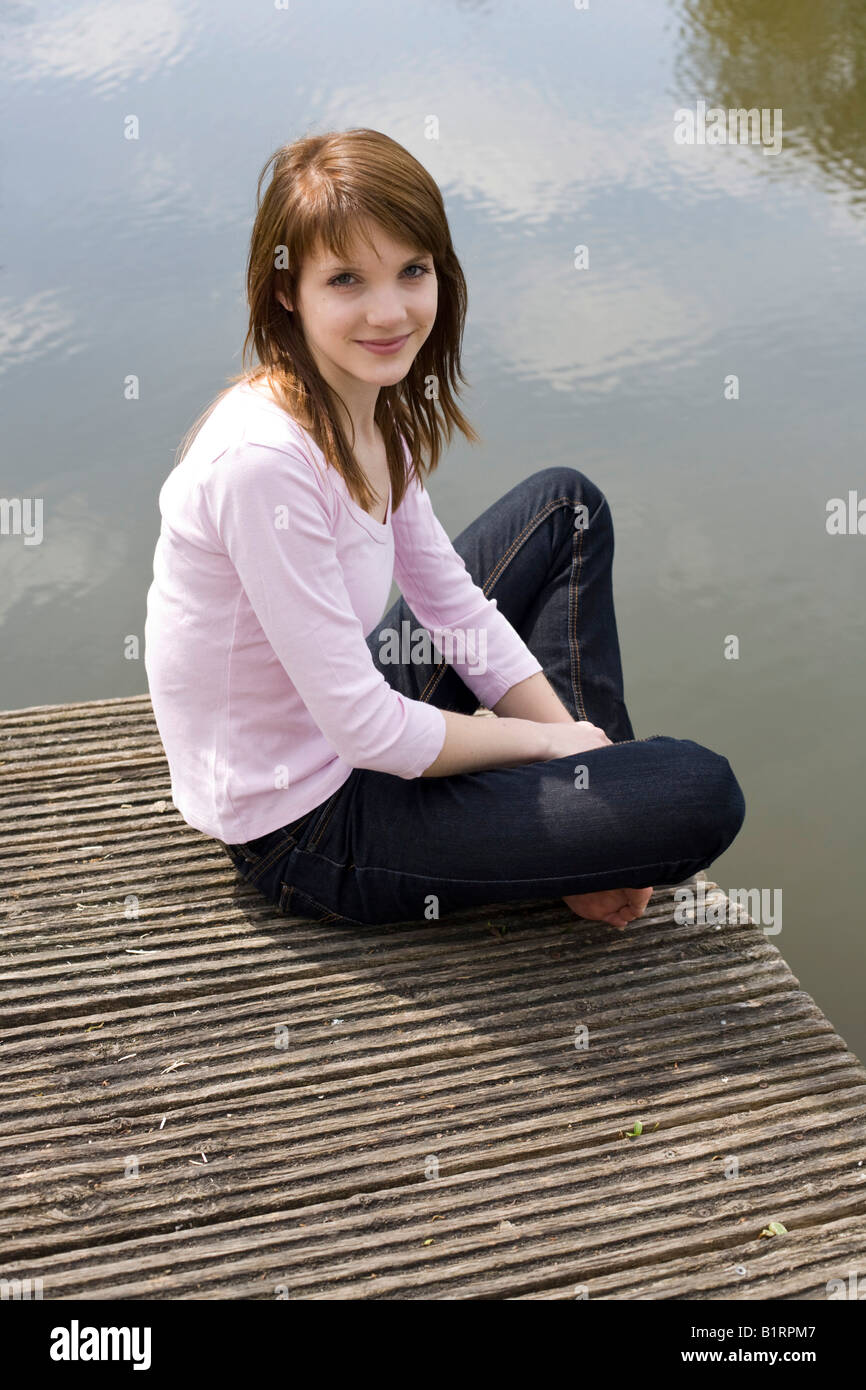 Jeune femme assise sur une jetée en bois, dock, à la friendly Banque D'Images